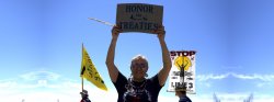 elder woman holding a sign to honor treaties