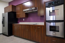 The lounge kitchen in Machuga Heights featuring a fridge and various ovens