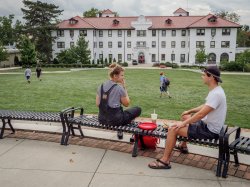 Two students sitting near the Freeman/Russ Quad enjoying a nice day.