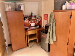 A student's desk and minifridge in a Blanton Hall Triple.