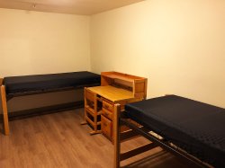 A double bedroom from an apartment at Hawk Crossings with two beds and desk.