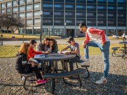 Students sitting outside of Blanton Hall having a conversation with one another.