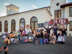 Students Holding Photojournalism Project Photos outside of School of Communication Building