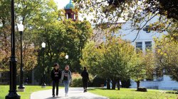 Students walking with college hall in the background