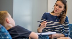 Image of a clinician talking with a child in a therapy session.