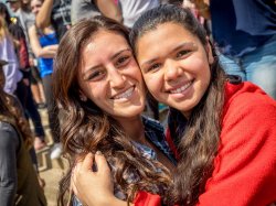 Image of two smiling students hugging.