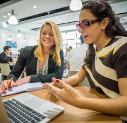 two entrepreneural students collaborating on a project with a laptop