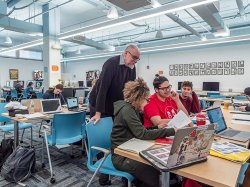 A faculty member helping some students in a design lab.