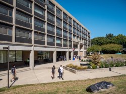 The outside of Blanton Hall on a sunny day with students walking around.