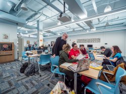 A faculty member helping some students in a design lab.