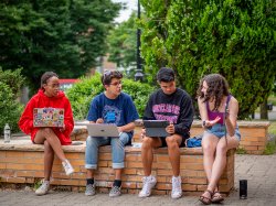 four students sitting and chatting