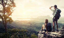 Student on cliff with sunset