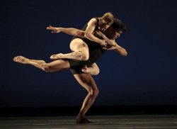 Photo of two dancers, one supporting the other, in dramatic pose.