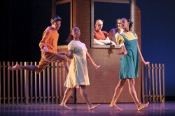 Photo of dancers in casual clothes in a street scene.