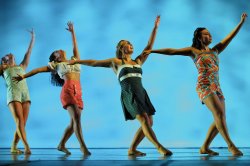 Photo of dancers with arms raised up
