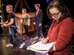 Students and Faculty discussing theatre set