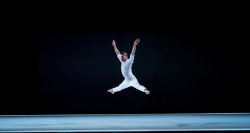 wide angle of dancer jumping into the air on stage