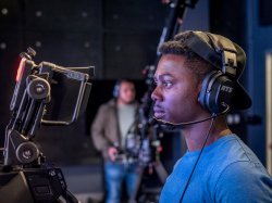 Student looking through camera in News Lab course.