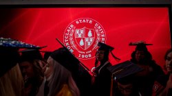 Montclair State University shield shown with the silhouettes of graduating students in the foreground