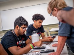 Upward Bound students in class working with teacher