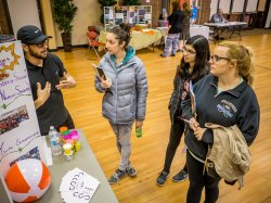 Students talking with a volunteer at the Community Service Fair.