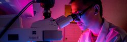 student using microscope to test water sample