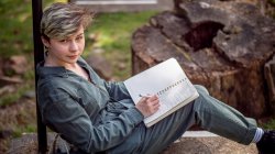 Natalya Kozlovski on outdoor steps with notepad