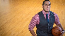 Gian Paul Gonzales in suit vest on basketball court