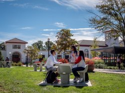 three students seated at outdoor table on Montclair campus