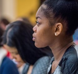 Photo of a student listening in a classroom setting.