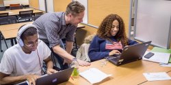 Photo of writing instructor helping students